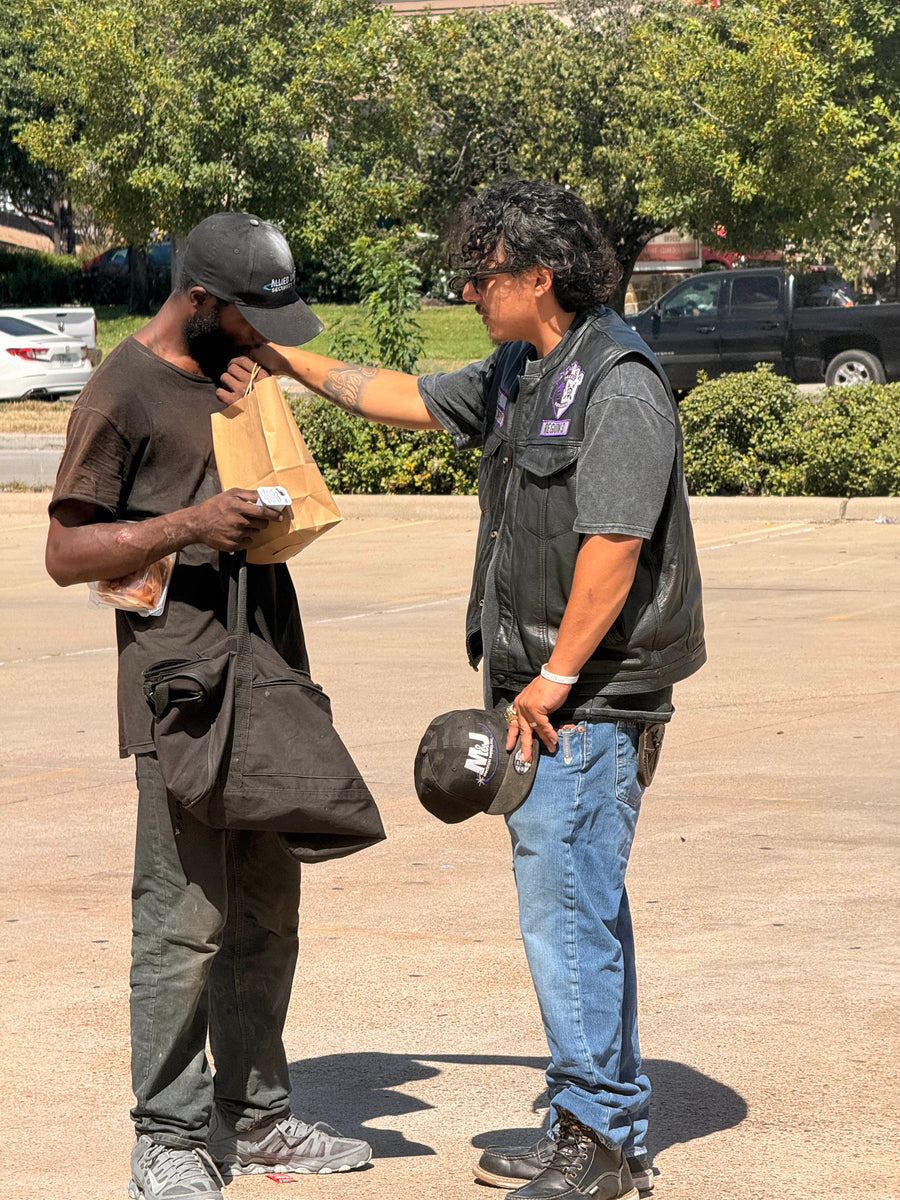Outreach team praying with a person beside a bicycle